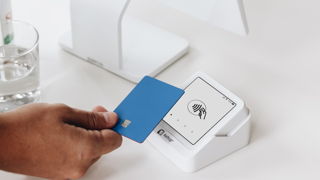 A person holding a card in front of a computer