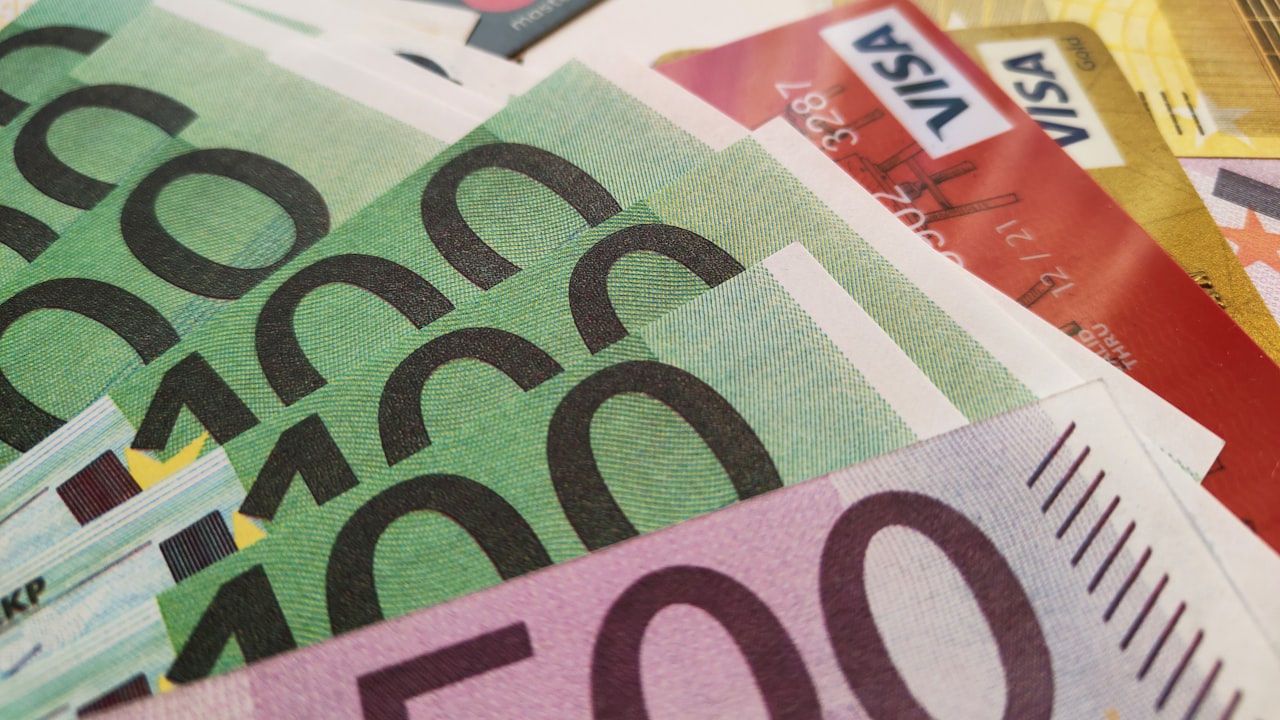 a pile of money with a credit card sticking out of it