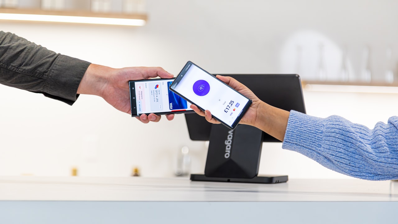 Customer paying with smartphone at point of sale terminal.