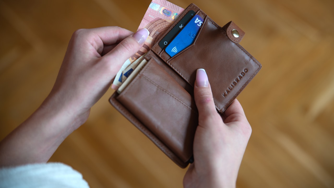 person holding brown leather card wallet