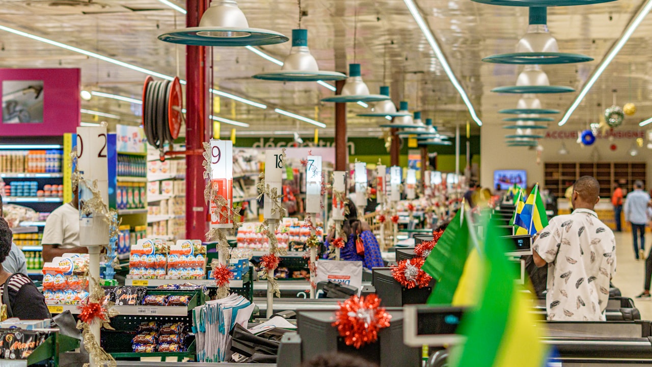 People shopping in a brightly lit supermarket aisle.