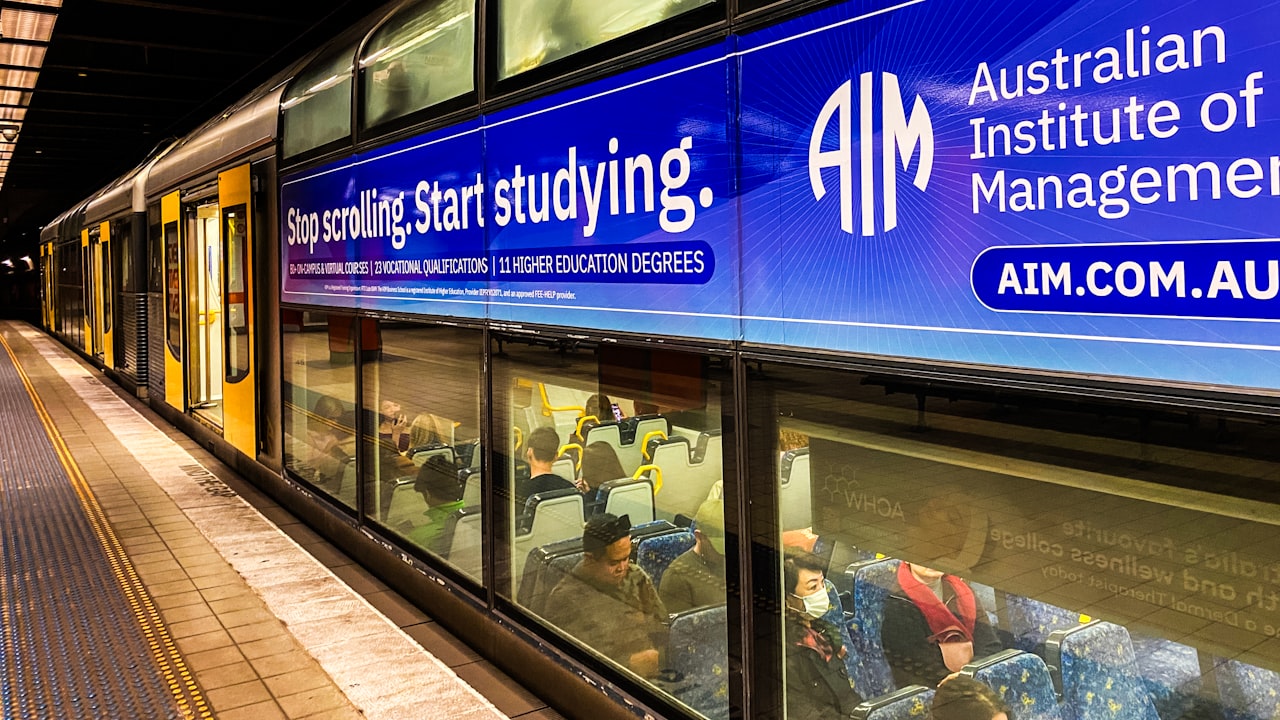A train station with a sign for the australian institution of management