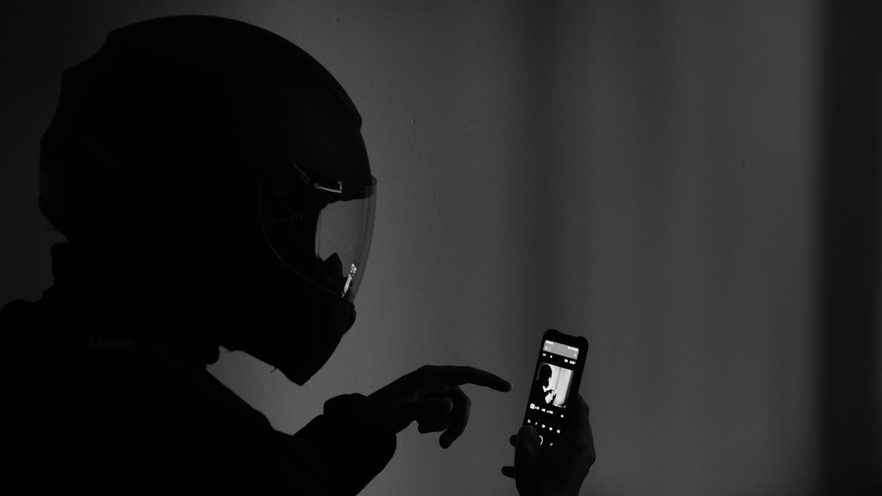 grayscale photography of man using smartphone