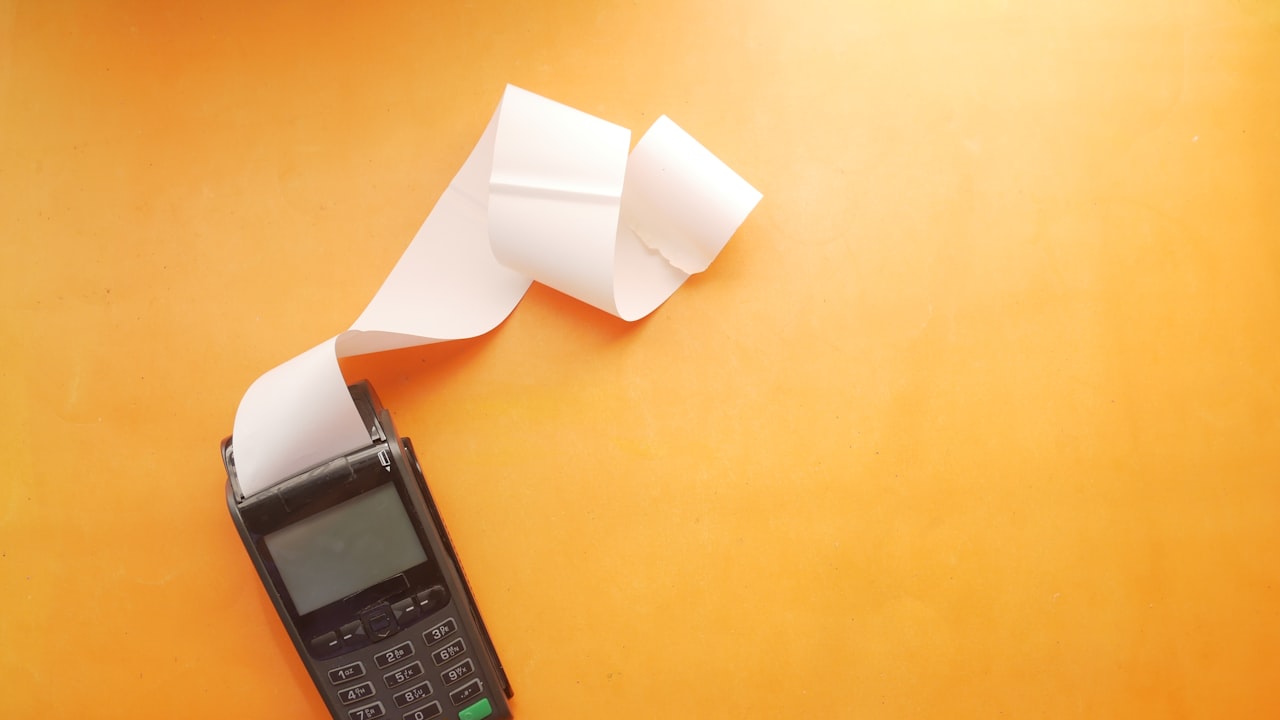 a cell phone sitting on top of a table next to a roll of paper