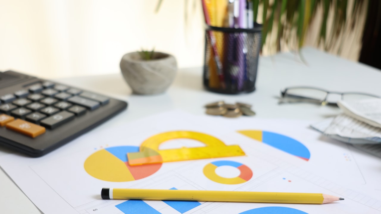 Desk with calculator, charts, and pencil