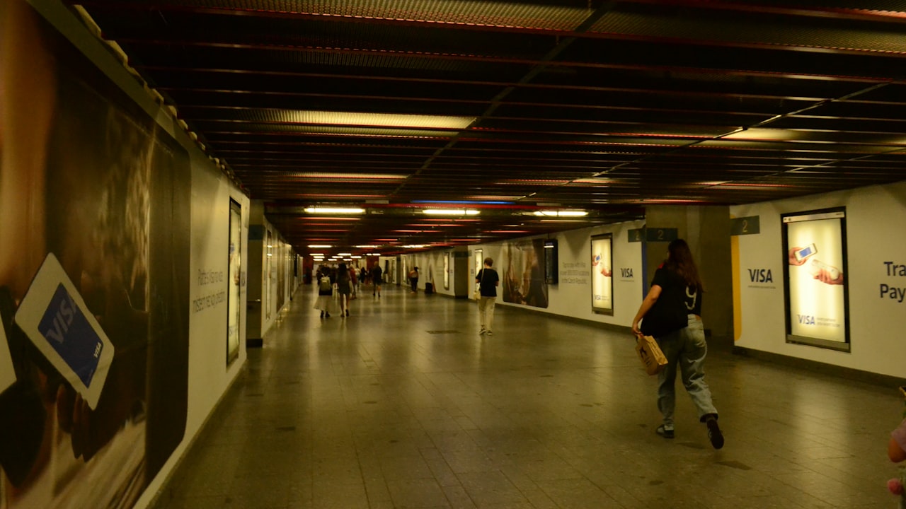 People walking through a long, brightly lit underground walkway.
