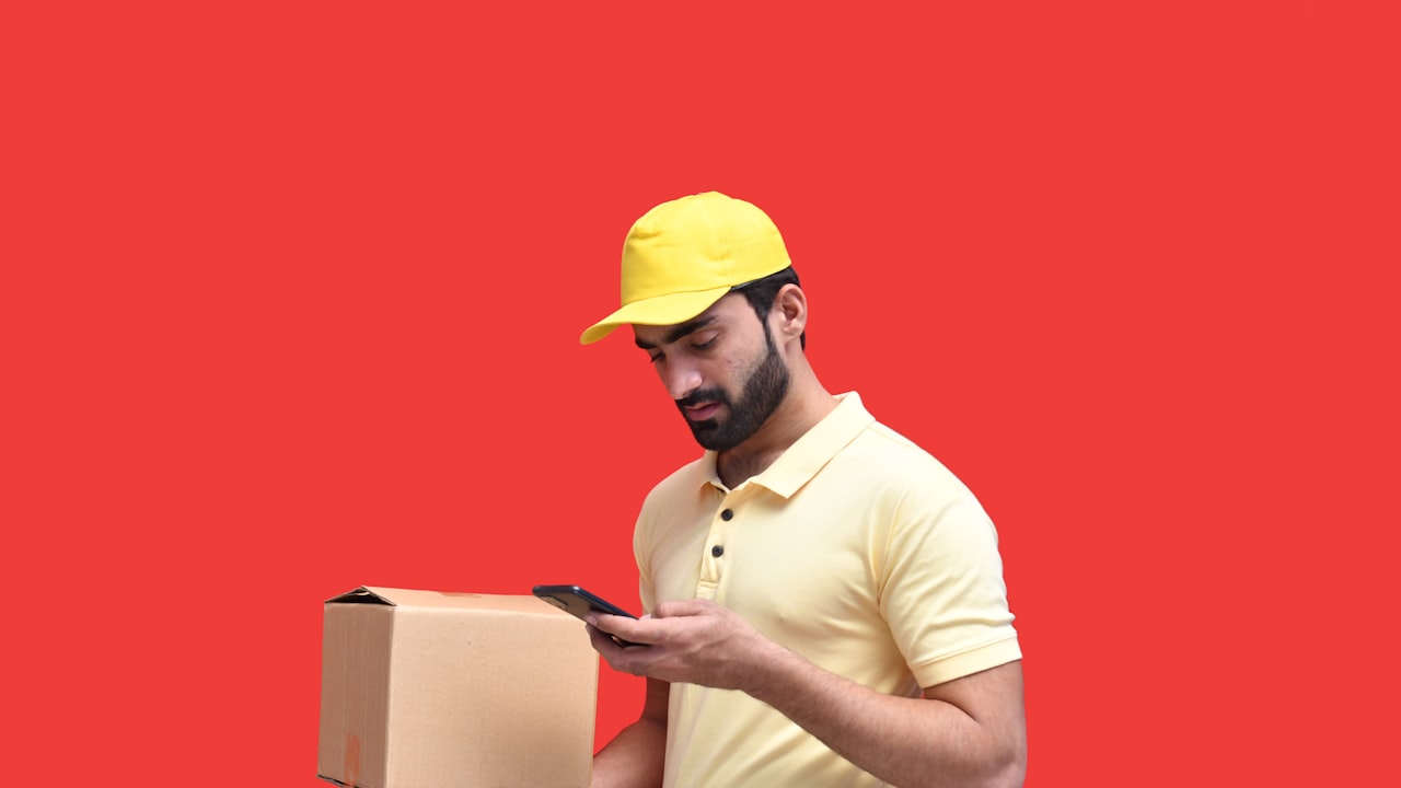 a man in a yellow hat looking at a phone
