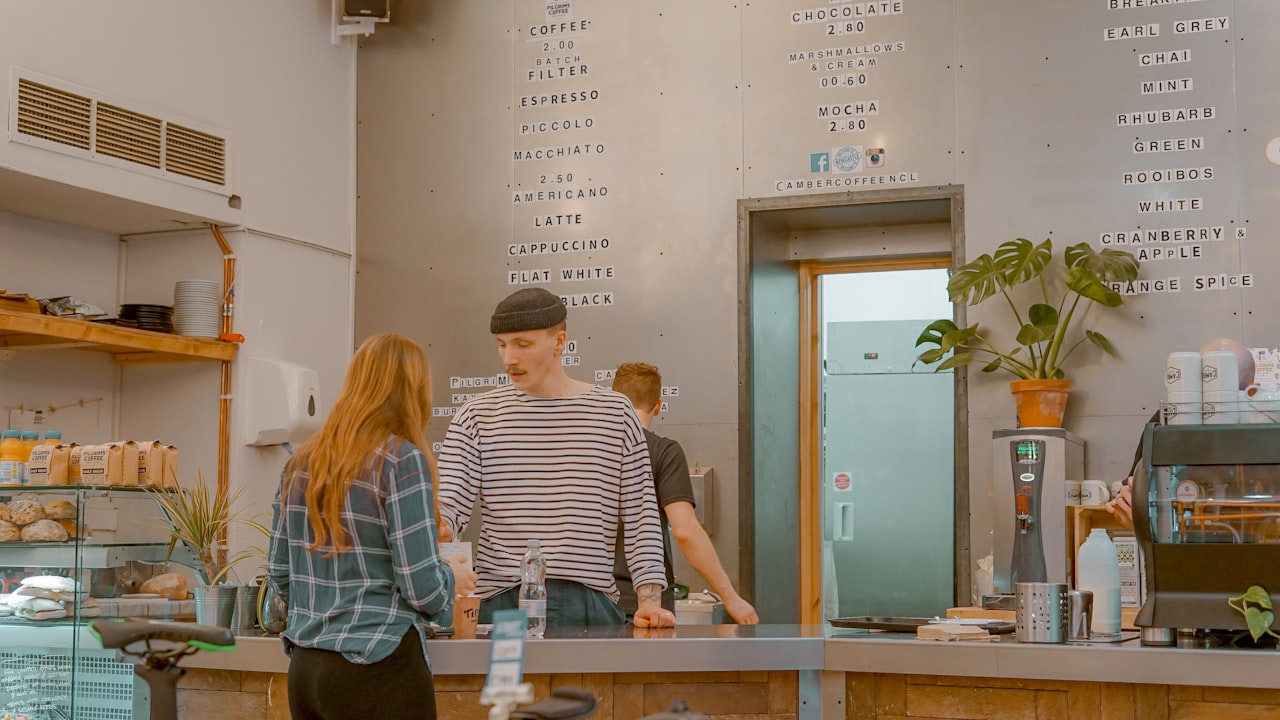man and woman talking in front of gray tabletop inside shop