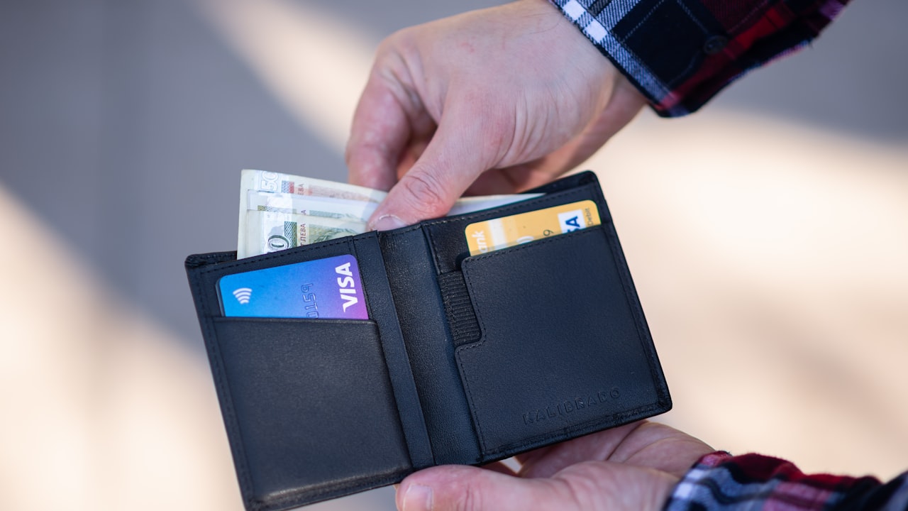 black leather bifold wallet on persons hand