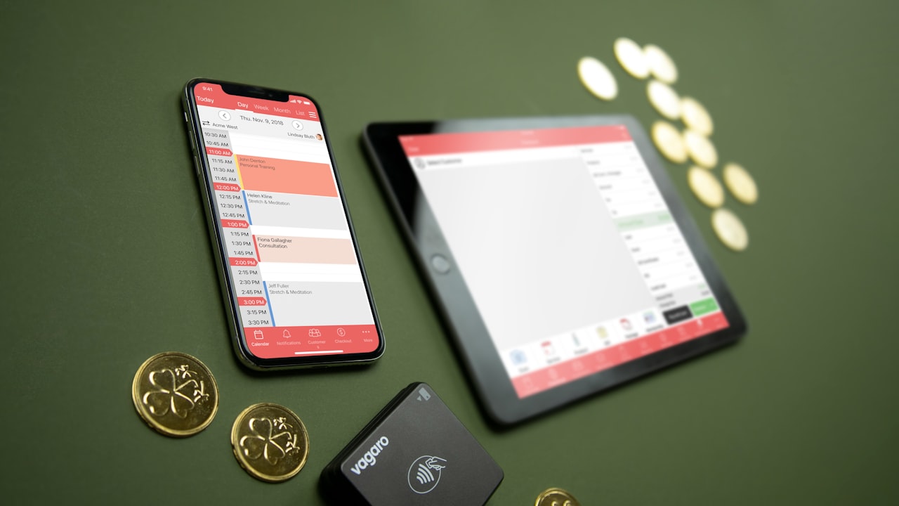 Smartphone, tablet, payment terminal, and coins on table