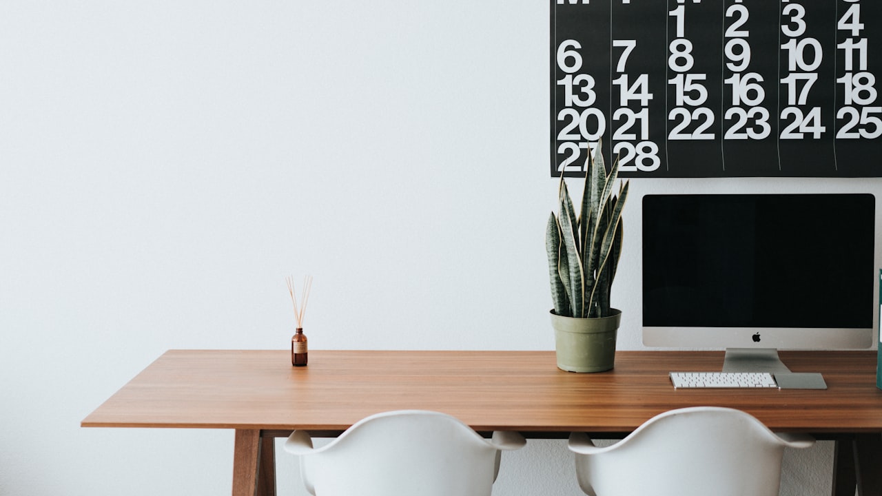 silver iMac on brown wooden desk